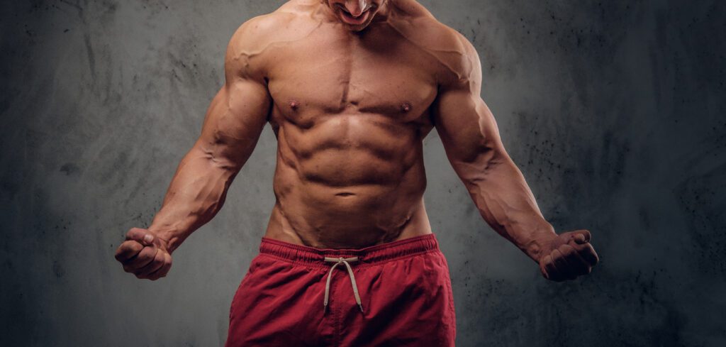 Powerful bodybuilder is posing on the dark background