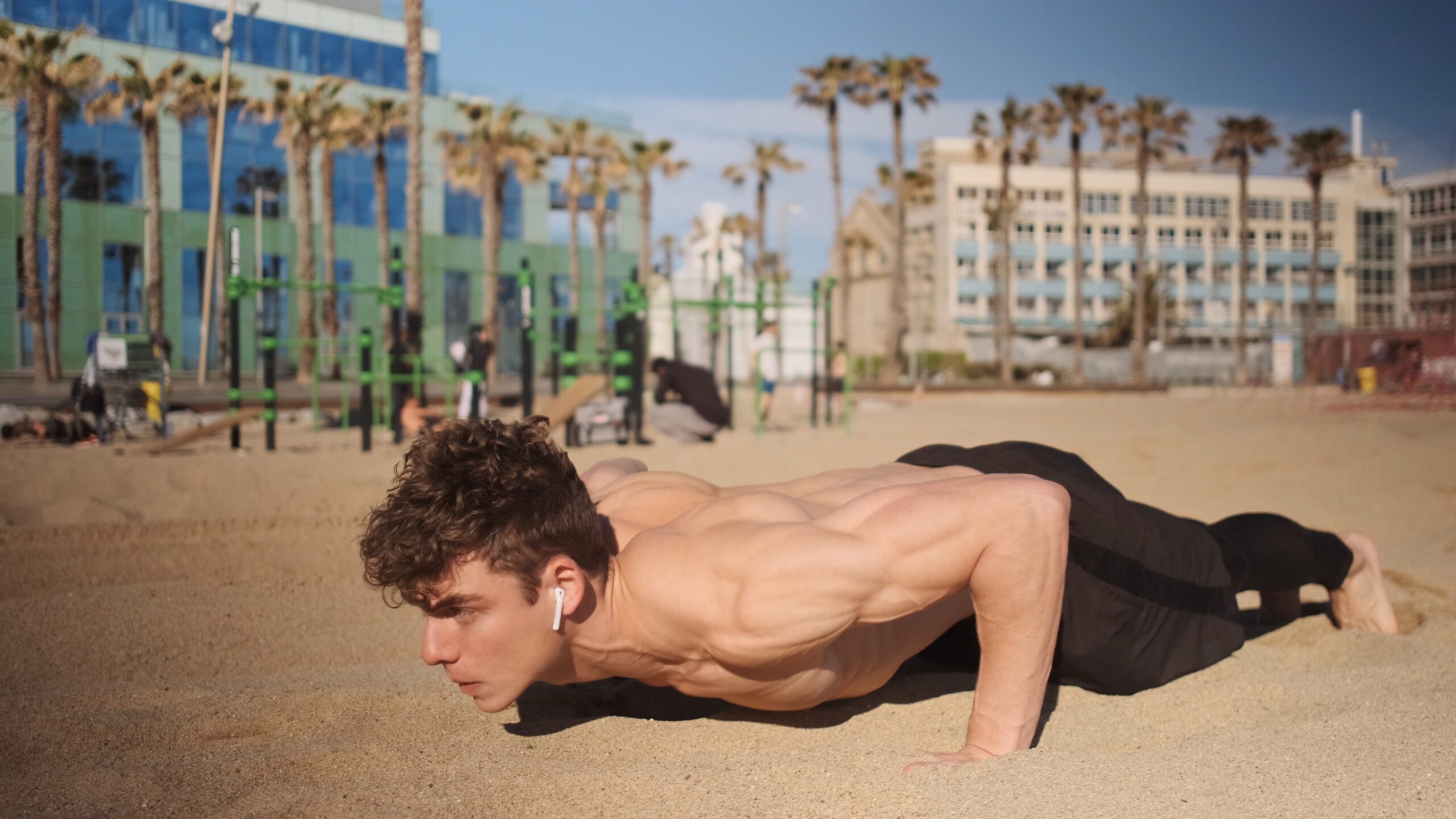 Young attractive man pushing-up during functional training on be