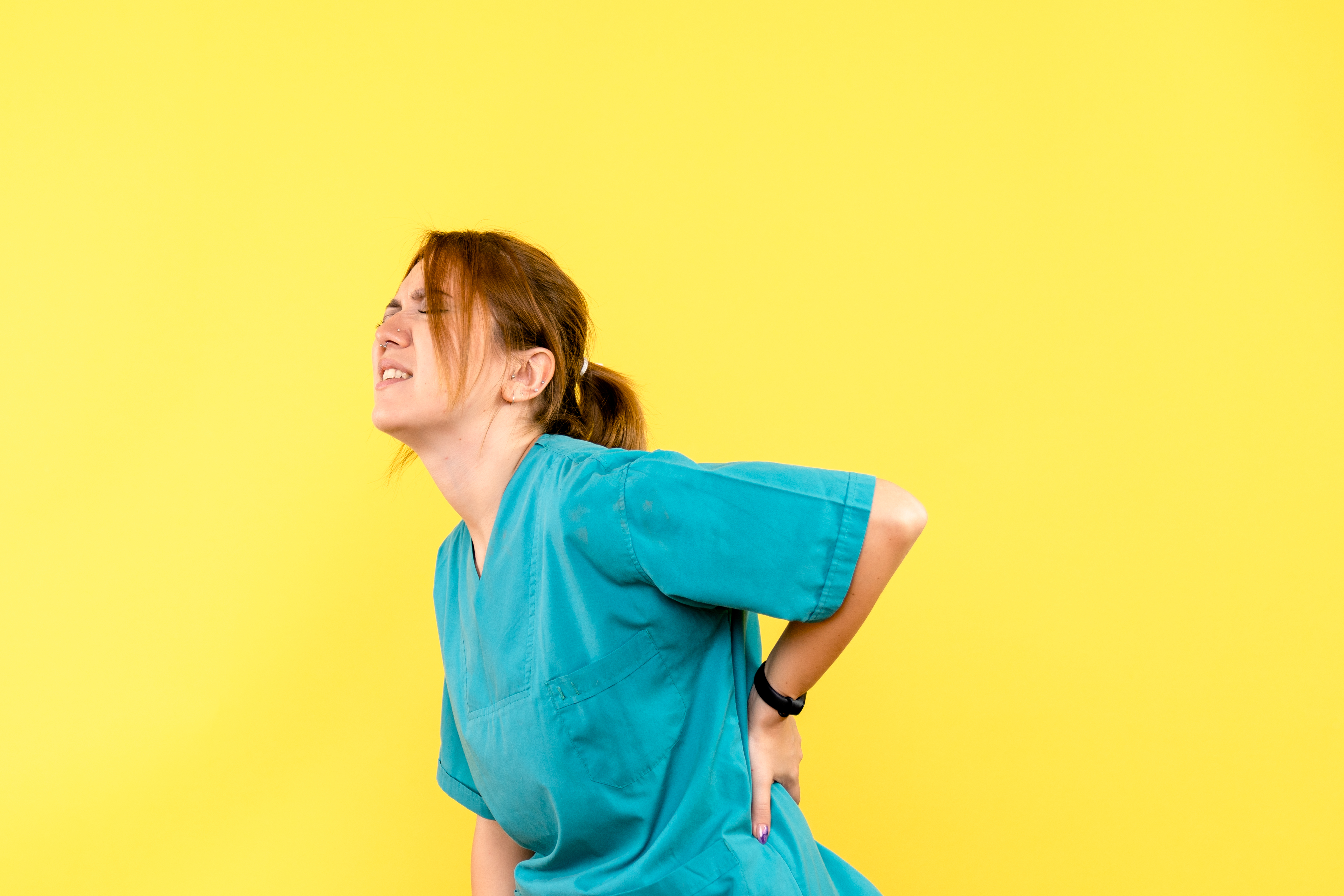front view female doctor having backache on yellow background em
