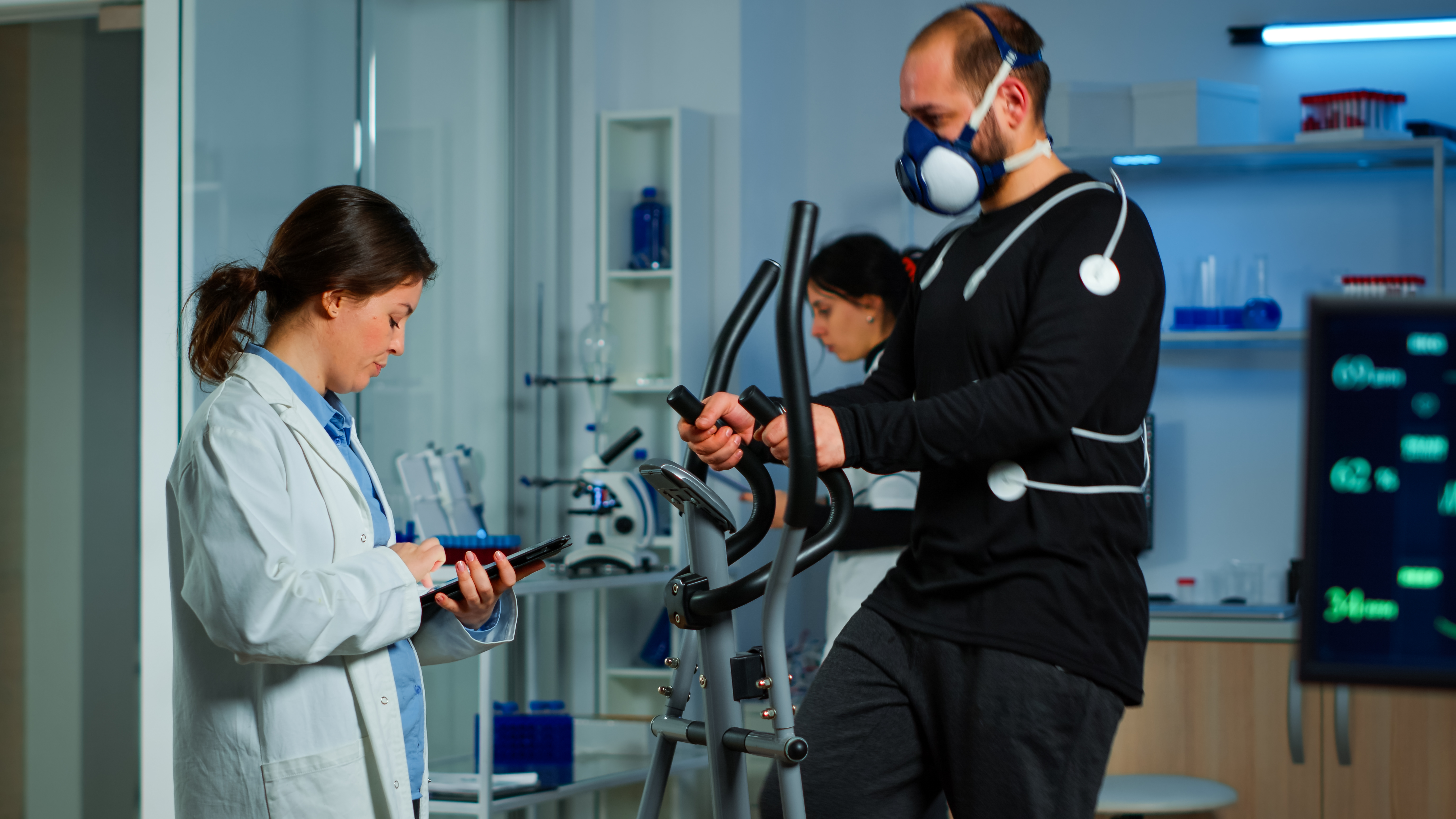 Doctor asking patient about his health while sportsman running on cross trainer